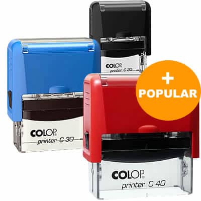 Vários modelos de carimbos automáticos COLOP nas cores azul, vermelho e preto, com destaque para o modelo mais popular