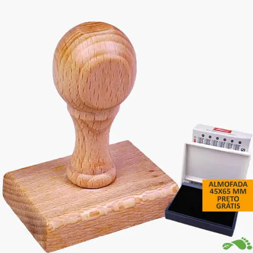 Carimbo de madeira com pega redonda ao lado de uma almofada de tinta, ideal para personalização artesanal.