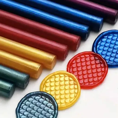 Tubos de lacre em várias cores com selos redondos estampados, usados para sinetes personalizados.
